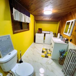 La salle de bains jaune est pourvue de toilettes et d'un lavabo. dans l'établissement A Princely Experience!, à Stoughton