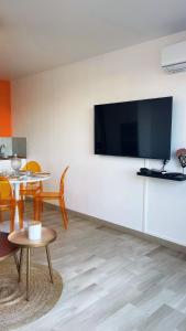 a living room with a large flat screen tv on a wall at Magnifique Appartement avec Vue Mer Panoramique in Nice