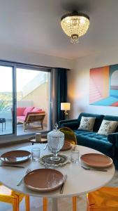 a living room with a table and a couch at Magnifique Appartement avec Vue Mer Panoramique in Nice