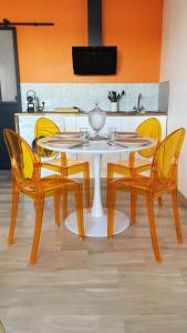 a table and chairs with a white table and yellow chairs at Magnifique Appartement avec Vue Mer Panoramique in Nice