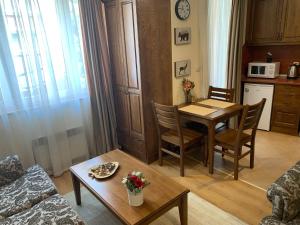 a living room with a table and chairs and a kitchen at Studio 5 in Pirin Golf in Razlog