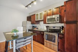 a kitchen with stainless steel appliances and wooden cabinets at CozySuites Mill District with pool, gym # 10 in Minneapolis +29 photos
