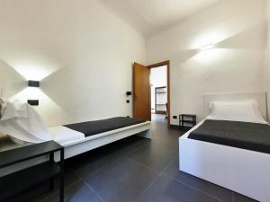 um quarto branco com 2 camas e um espelho em Sant'Agostino XXXII em La Spezia