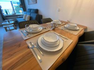 a wooden table with plates and wine glasses on it at Ferienwohnung Ostseeverliebt 1-6-1 in Kellenhusen