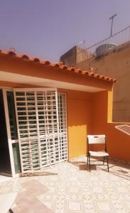 una silla sentada frente a una casa en RoofTop Apt en Praia