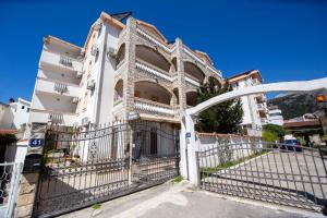 a white building with a gate in front of it at Villa Ipera in Budva