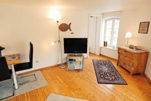 ein Wohnzimmer mit einem TV auf einem Holzboden in der Unterkunft Altstadtsonne 2 - ABC35 in Wismar