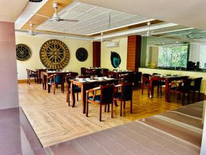 un restaurante con mesas y sillas en una habitación en Riviera Resort By Live Inn Rishikesh, en Bijni