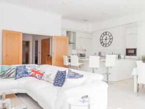 a white living room with a white couch and a kitchen at Bay Sea View in Torquay