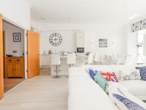 a living room with a white couch and a kitchen at Bay Sea View in Torquay
