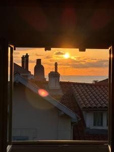 una vista de la puesta de sol desde el techo de una casa en Superbe appartement plein centre de Biarritz, en Biarritz