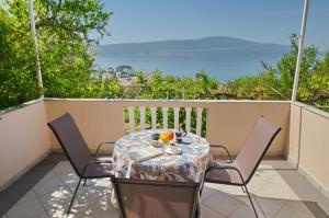 una mesa y sillas en un balcón con vistas al océano en Porto Lastva Apartments en Tivat