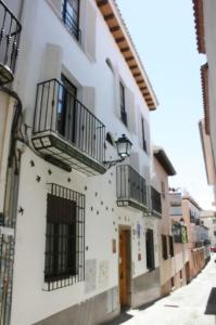 un edificio con balcones al lado de una calle en Golondrinas de la Alhambra, en Granada