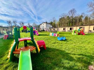een park met kleurrijke speeltoestellen in het gras bij Ośrodek rodzinny "Pod Wydmami" PRZY PLAŻY , PLAC ZABAW , ROWERY in Sarbinowo