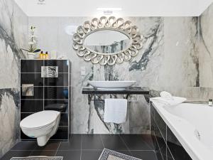 a bathroom with a sink toilet and a mirror at SKY9 Apartments - Homes & Villas in Vösendorf