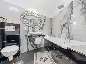 a bathroom with a sink toilet and a mirror at SKY9 Apartments - Homes & Villas in Vösendorf