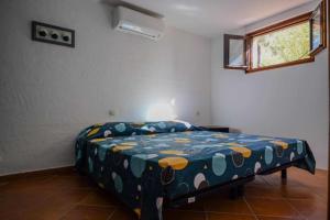 una camera da letto con un letto con un piumone blu e una finestra di Villa vue mer, Climatisée a Olmeto