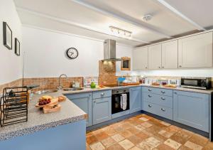 cocina con armarios azules y encimera en Trevow en Pendeen
