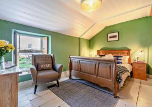 1 dormitorio con 1 cama, 1 silla y 1 ventana en Trevow en Pendeen
