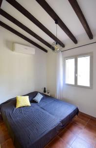1 dormitorio con 1 cama azul en una habitación blanca en Villa vue mer, Climatisée, en Olmeto