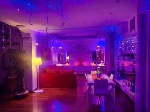 ein Wohnzimmer mit lilafarbener Beleuchtung und einer Couch in der Unterkunft Charme e Benessere in home suite in Portici