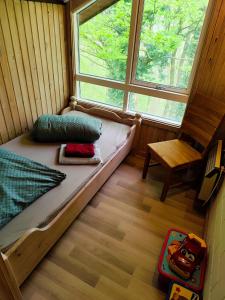 a bed in a room with a window and a chair at Premium-Ferienhaus Extertal Ferienpark - Natur Erholung Sauna Familie in Extertal