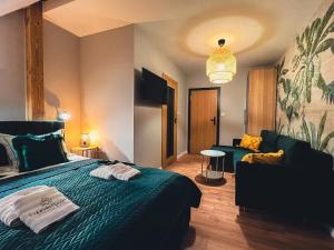 ステンジツァにあるLubiński Resortのベッドとソファ付きのホテルルーム