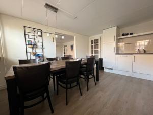 a kitchen and dining room with a table and chairs at De Skuorre in Baaiduinen