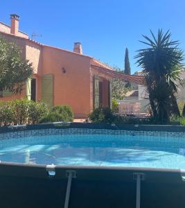 a large swimming pool in front of a house at Grande maison 132m2 avec jardin et piscine à 15min de la plage in La Crau