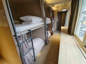 Rúm í herbergi á 日初青旅 Sundaily Hostel 北車