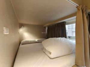 Rúm í herbergi á 日初青旅 Sundaily Hostel 北車