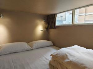 Rúm í herbergi á 日初青旅 Sundaily Hostel 北車