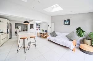 a white living room with a couch and a kitchen at Pass the Keys Stylish Family Home in Hersham