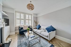 a living room with a couch and a table at Pass the Keys Stylish Family Home in Hersham