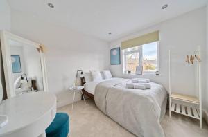 a white bedroom with a bed and a sink at Pass the Keys Stylish Family Home in Hersham