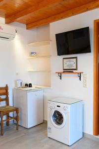 eine Waschküche mit einer Waschmaschine und einem TV an der Wand in der Unterkunft Kontaratos Studios & Apartments in Parikia