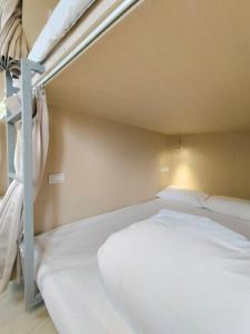 Rúm í herbergi á 日初青旅 Sundaily Hostel 北車