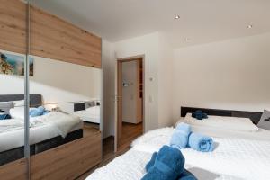 a bedroom with two beds and a mirror at Haus Alpenlieb in Wörgl