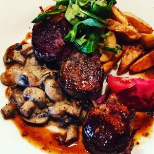 a plate of food with meat and mushrooms and vegetables at Pension Bílý Hořec in Vrchlabí +61 photos