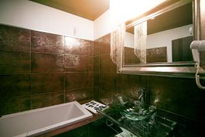 ein Bad mit einem Waschbecken und einem Spiegel in der Unterkunft Hotel ACG in Los Villares
