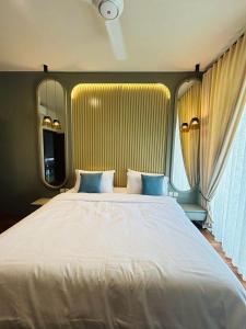 uma grande cama branca com almofadas azuis num quarto em The Grand ward place colombo 7 super Luxury 2 bedroom apartment em Colombo