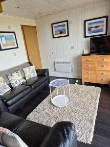 ein Wohnzimmer mit einem Sofa und einem Tisch in der Unterkunft SPECTAULAR SEA VIEWS! at Kingsdown Park, with Swimming pool No118 in Kingsdown