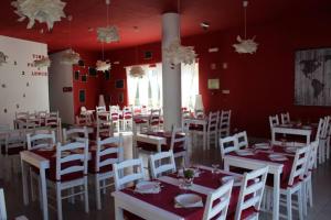 a dining room with white tables and white chairs at Kampaoh Tavira in Tavira