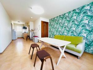 uma sala de estar com uma mesa e um sofá verde em Hakodate Stoke Hills em Hakodate