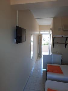 a living room with a couch and a tv on a wall at Arsuz Yunus Otel Bungalow in Arsuz