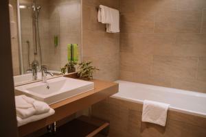 圣兰布雷希特Hotel Auszeit St Lambrecht的带水槽和浴缸的浴室