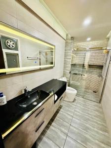 a bathroom with a sink and a toilet and a shower at Designer's Luxe Delight-Elysium Tower in Islamabad