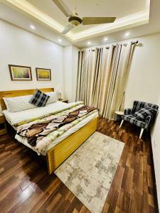 a bedroom with a large bed and a chair at Designer's Luxe Delight-Elysium Tower in Islamabad