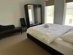 Happy House في Melton South: غرفة نوم مع سرير مع اثنين من الحيوانات المحشوة عليه