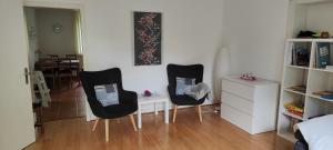 Zimmer mit 2 Stühlen, einem Schreibtisch und einem Schlafzimmer in der Unterkunft Ferienwohnung im Herzen der Lüneburger Heide in Soltau